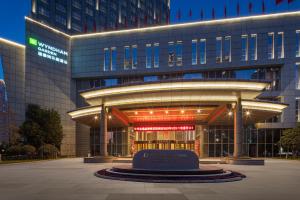 un edificio con una estatua delante de él en Wyndham Garden Changzhou Zhonglou en Changzhou