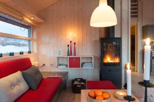 a living room with a red couch and a fireplace at Sørbølhytta - cabin in Flå with design interior and climbing wall for the kids in Flå