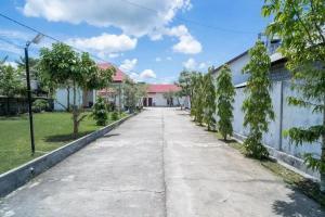 una calle vacía en una casa con árboles en RedDoorz Syariah Near Syamsudin Noor Airport 4 en Ulin