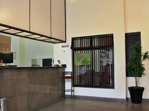 um lobby com um balcão e um bar com uma planta em Scala Residence Hotel em Resende