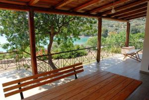 een veranda met een bank en uitzicht op een meer bij Cottage by the sea in Áyios Dhimítrios