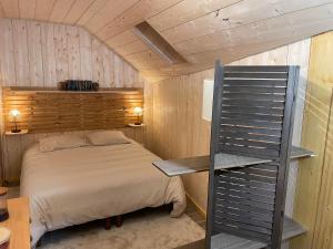 a bedroom with a bed and a wooden wall at Le Chalet de Carole in Cadéac