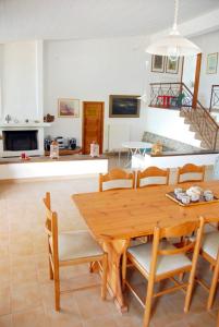 een keuken en eetkamer met een houten tafel en stoelen bij Cottage by the sea in Áyios Dhimítrios