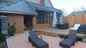 a patio with two chairs and a table on a deck at Le Chalet de Carole in Cadéac