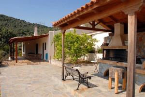 een patio met een bank en een buitenoven bij Cottage by the sea in Áyios Dhimítrios