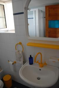 een badkamer met een wastafel en een spiegel bij Cottage by the sea in Áyios Dhimítrios