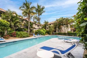 una piscina con tumbonas y un complejo en BEST Ground Floor pool side Superior apartment - new listing en Gold Coast