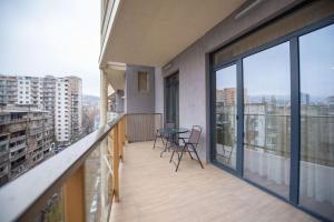 a balcony with a table and chairs in a building at GG Home - spacious, cozy 3-bedroom apartment in Saburtalo in Tbilisi City