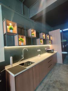 eine Küche mit einem Waschbecken und einem großen Spiegel in der Unterkunft Smile Hotel Seri Kembangan in Seri Kembangan