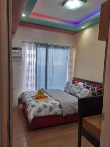 um quarto com uma cama com um gato sentado nela em Chic and Cozy 1-Bedroom Condo em Cagayan de Oro