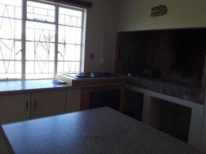 a kitchen with a table and a large window at Abbastanza Self-catering in Loeriesfontein