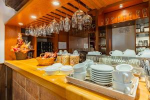 a buffet line with plates and bowls and chandeliers at Hotel Amadeus in České Budějovice