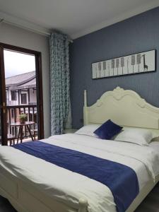 a bedroom with a large bed and a balcony at Jiamen Inn in Emeishan City