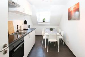 a kitchen and dining room with a table and chairs at Spacious Apartment with Balcony & WiFi in Wetzlar
