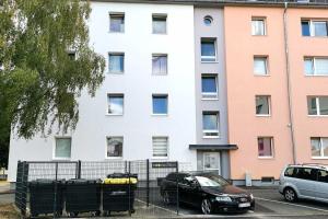 two cars parked in a parking lot in front of a building at Spacious Apartment with Balcony & WiFi in Wetzlar