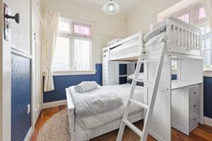 sypialnia z 2 łóżkami piętrowymi i biurkiem w obiekcie The Bungalow w mieście Hamilton