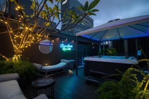 una terraza con jacuzzi y una señal en un edificio en Hotel NuVe Elements, en Singapur