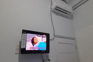 a flat screen tv hanging from a wall at SPOT ON 92236 Kediri Family Homestay in Medan