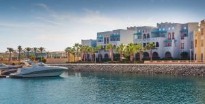a boat docked in the water in front of a building at Fanadir Hotel El Gouna in Hurghada