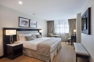 a hotel room with a large bed and a desk at Miramar By Windsor Copacabana in Rio de Janeiro