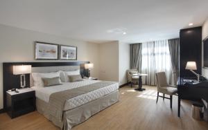 a hotel room with a large bed and a desk at Miramar By Windsor Copacabana in Rio de Janeiro