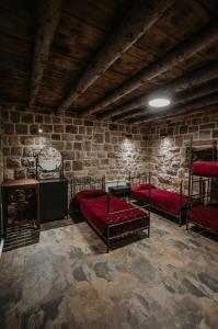 a room with three bunk beds in a brick wall at Cedar Scent Guesthouse in Batroûn