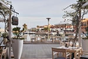 een restaurant met tafels en stoelen en een jachthaven bij Captain's Inn Hotel in Hurghada