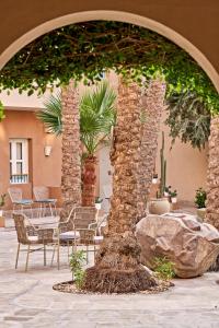 un arco con sedie e alberi in un cortile di Captain's Inn Hotel a Hurghada