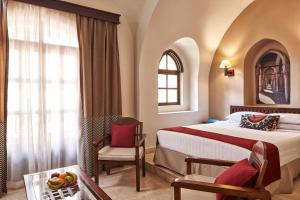 a hotel room with a bed and a chair at Hotel Sultan Bey Resort in Hurghada