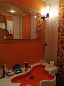 a bathroom with a red sink and a mirror at Dari Guest Rooms Стаи за гости Дари in Nesebar