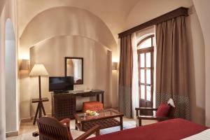 a hotel room with a bed and a television at Hotel Sultan Bey Resort in Hurghada