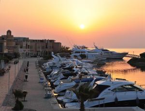 eine Gruppe von Booten, die bei Sonnenuntergang in einem Yachthafen geparkt sind in der Unterkunft Mosaique Hotel El Gouna in Hurghada