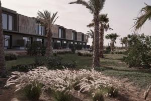 un edificio con palmeras delante en Casa Cook El Gouna - Adults Only en Hurghada