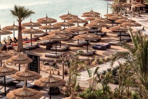 a bunch of straw umbrellas on a beach at Cook’s Club El Gouna (Adults Only) in Hurghada