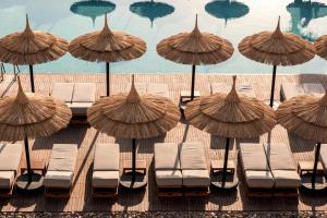 洪加達的住宿－Cook’s Club El Gouna (Adults Only)，海滩上的一组椅子和遮阳伞