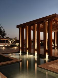 a building with a pool of water with pillars at The Chedi El Gouna in Hurghada