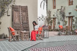 uma mulher sentada numa cadeira em frente a um edifício em Ali Pasha Hotel em Hurghada