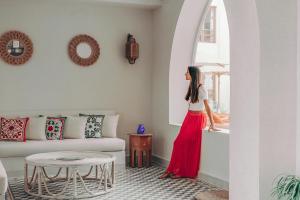 a woman standing in a living room looking out a window at Ali Pasha Hotel in Hurghada