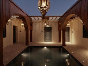 an indoor swimming pool in a house with a chandelier at The Chedi El Gouna in Hurghada