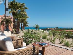a patio with a table and chairs and the ocean at The Chedi El Gouna in Hurghada