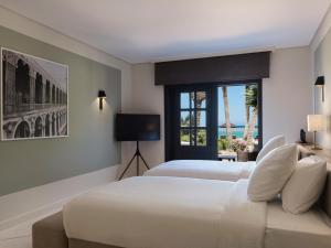 a hotel room with two beds and a window at The Chedi El Gouna in Hurghada
