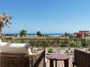 a patio with a table and chairs and the ocean at The Chedi El Gouna in Hurghada