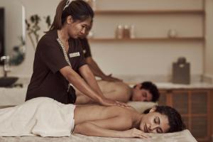 Una mujer recibiendo un masaje de un hombre en una cama en The Chedi El Gouna, en Hurghada