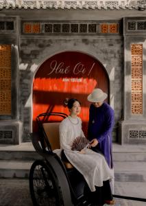 Una foto de un hombre y una mujer en un rickshaw en Rosaleen Boutique Hotel en Hue