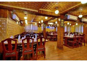 a restaurant with wooden tables and chairs and people sitting at them at hotel khalil in Gulmarg