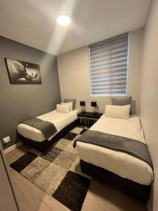 um quarto com 2 camas e uma janela em Stunning 2 Bedroom Apartment in Rosebank Central em Joanesburgo