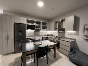 uma grande cozinha com uma mesa e cadeiras em Stunning 2 Bedroom Apartment in Rosebank Central em Joanesburgo