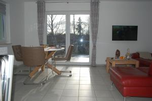 a living room with a table and a couch at Behagliches Ferienhaus Zaunkönig -mit Kamin und Sauna in Tanne