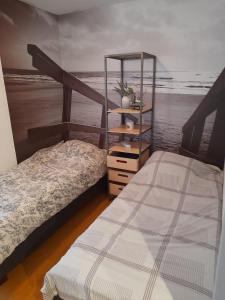 two beds in a room with the ocean in the background at Residentie Canada in Blankenberge