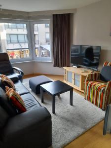 a living room with two couches and a tv at Residentie Canada in Blankenberge